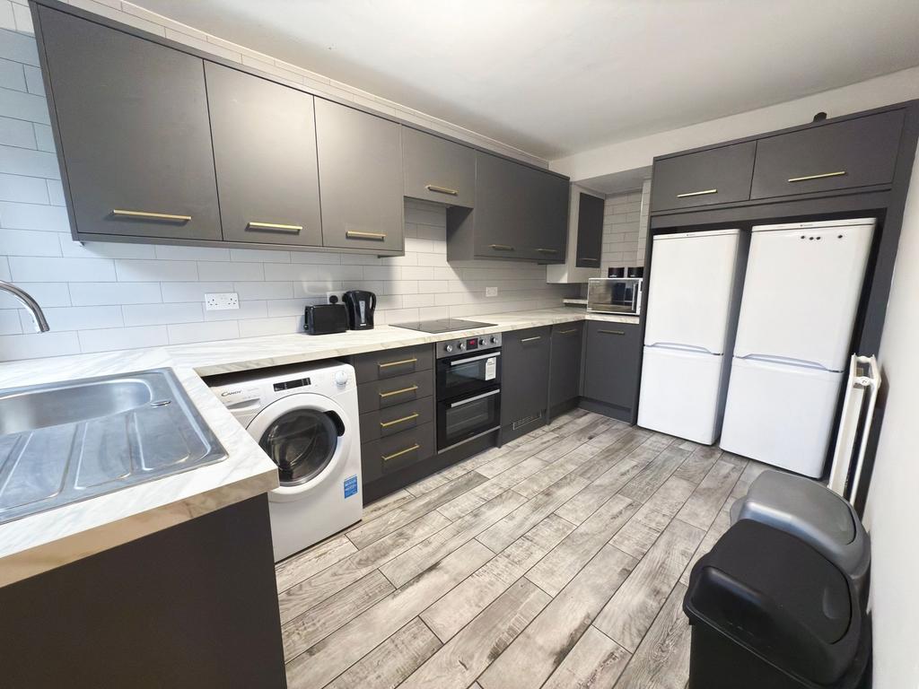 Modern fitted kitchen with dark matte cabinets,...