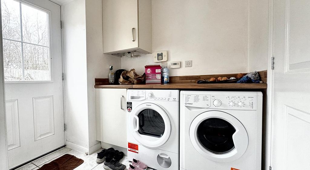 Bright utility-style kitchen area with front do...