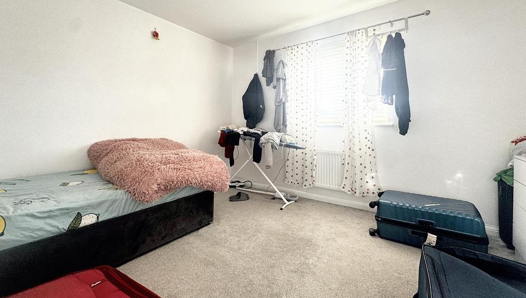 Bright, simply furnished bedroom with a large w...