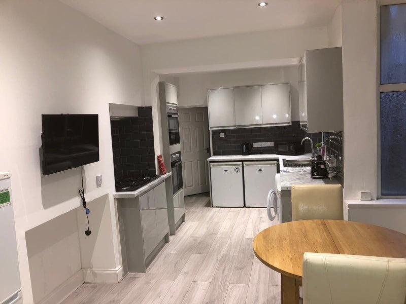 Modern open-plan kitchen with sleek grey cabine...