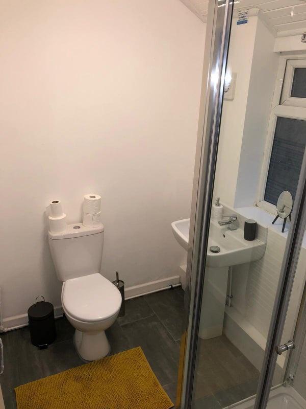 Compact, modern bathroom with a corner shower, ...