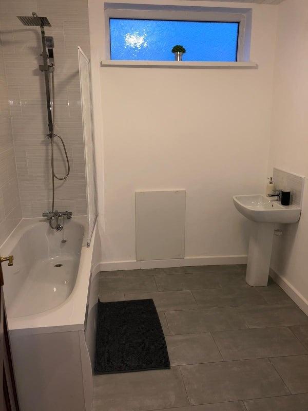 Bright modern bathroom with a full bathtub and ...