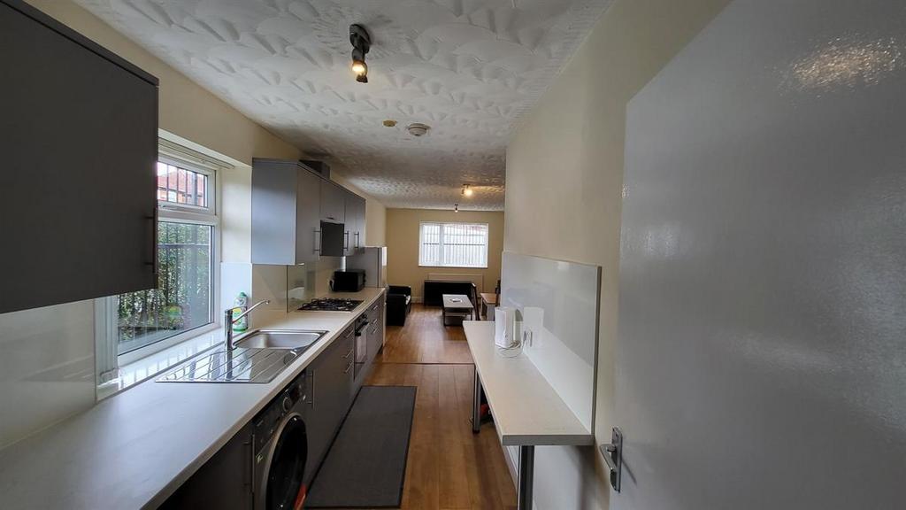 Bright galley-style kitchen with long worktops,...