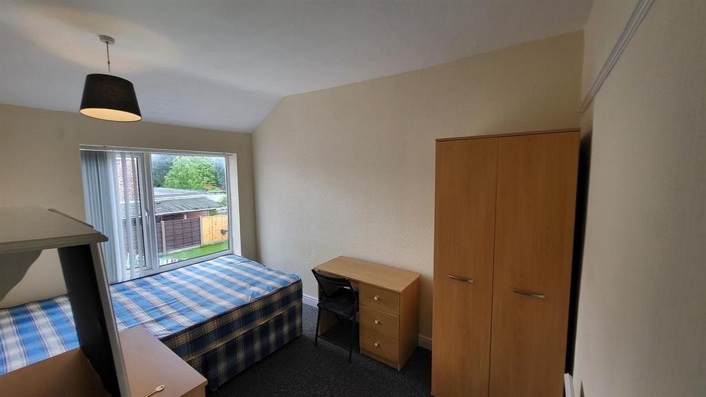 Neat single bedroom with a large window and sli...