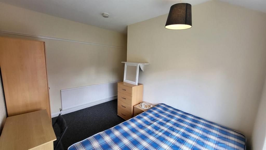 Bright, simply furnished bedroom with a double ...
