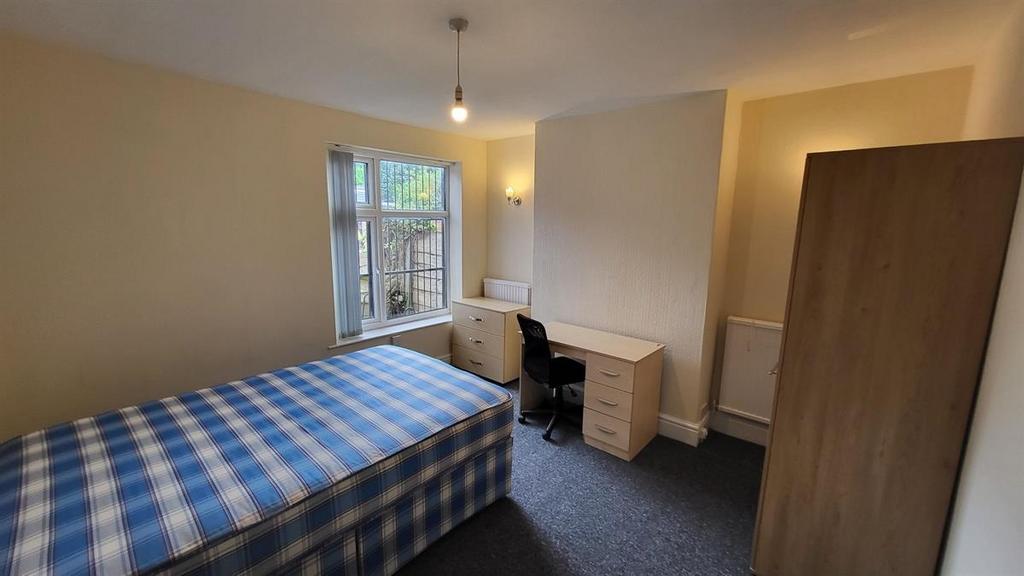 Neat single bedroom with a comfortable bed, des...