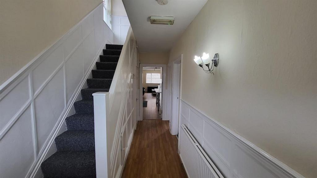 Bright, neatly maintained hallway with wood-eff...