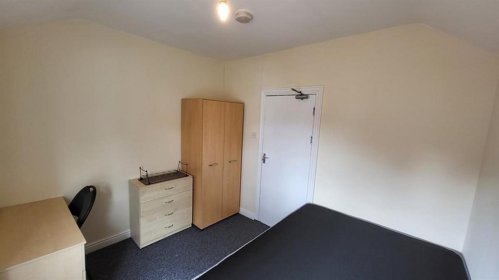 Bright, simply furnished bedroom with a double ...