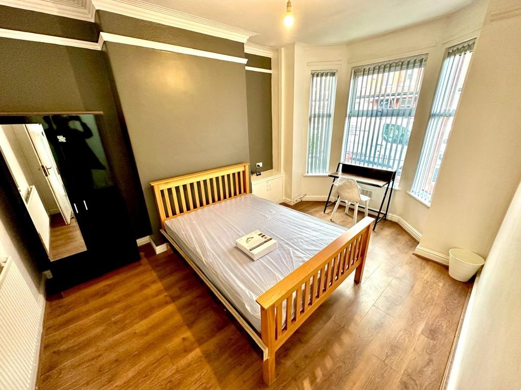 Bright, well-kept double bedroom with a wooden ...
