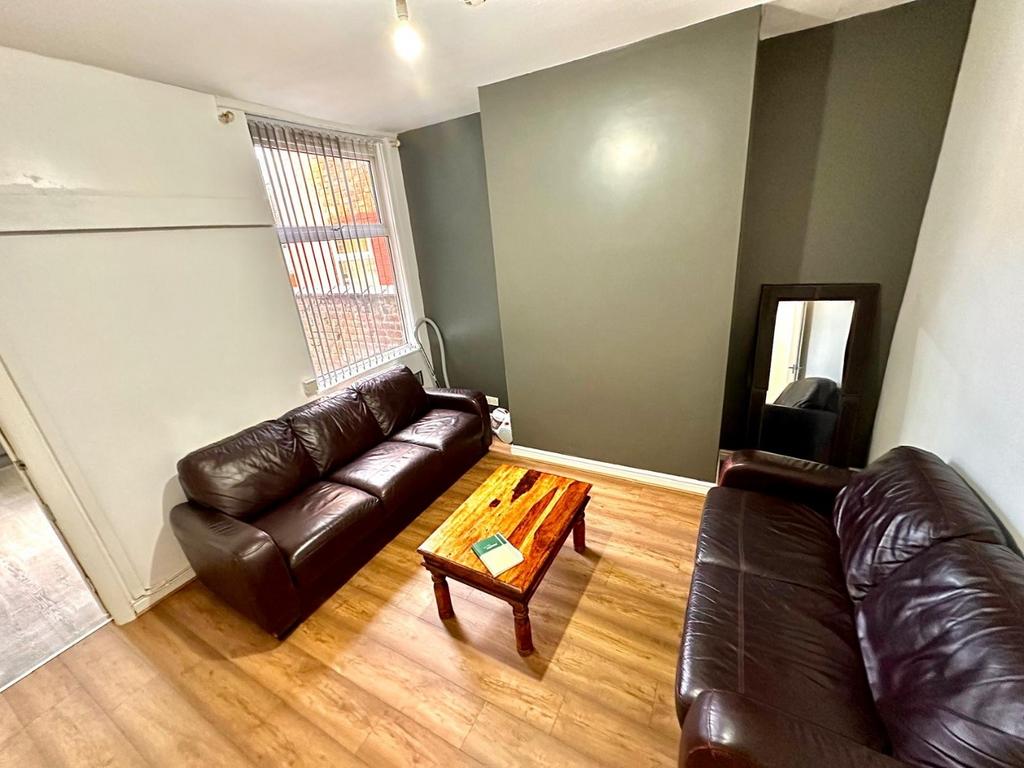 Bright furnished living room with two leather s...