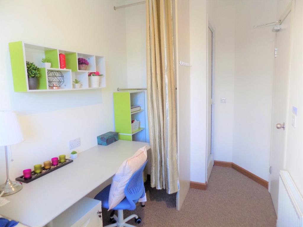 Bright, neatly arranged bedroom corner with a l...