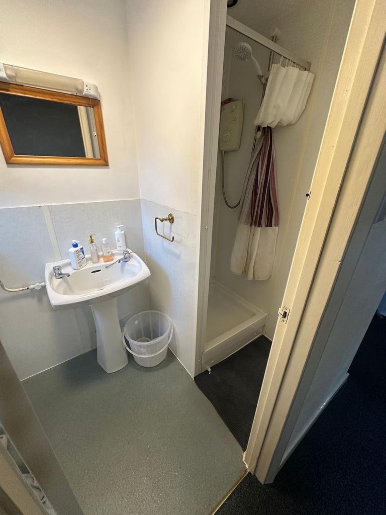 Compact ensuite bathroom with a pedestal sink, ...