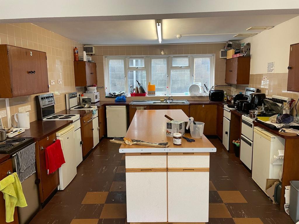 Large shared kitchen with a central island, mul...
