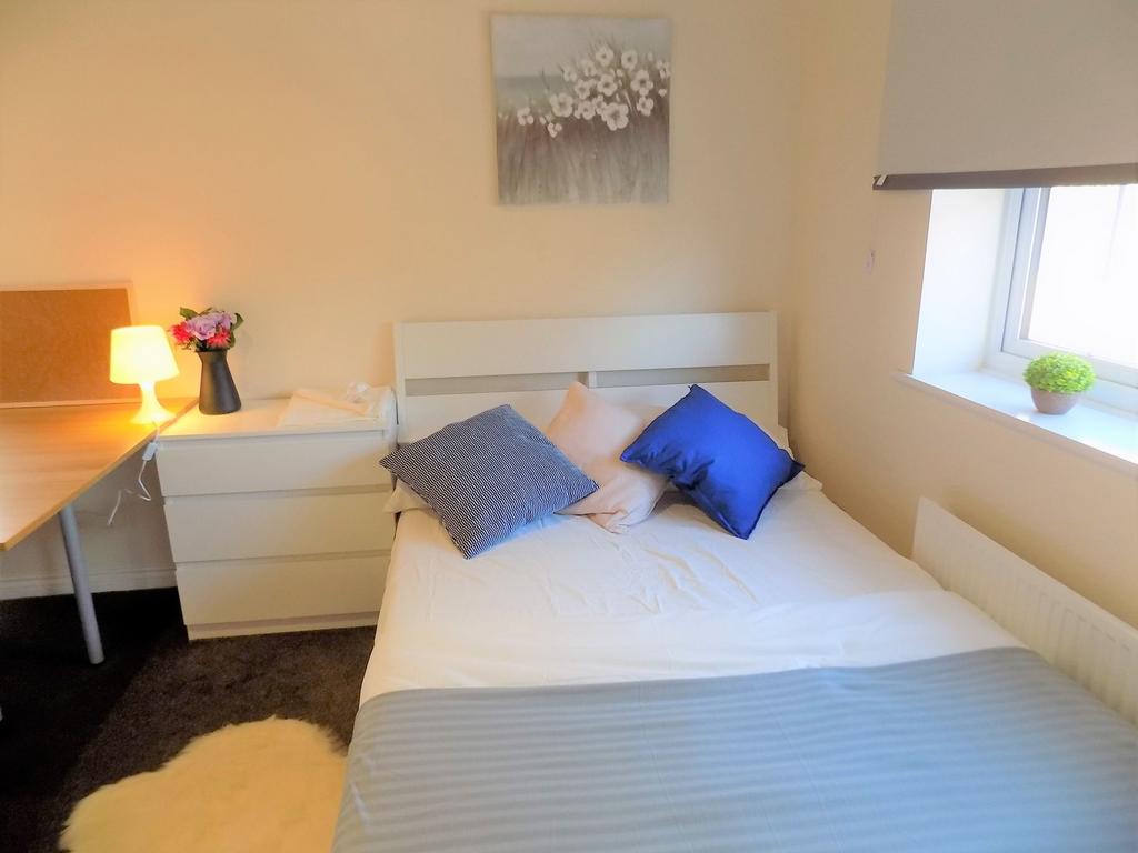 Bright, neatly styled bedroom with a comfortabl...
