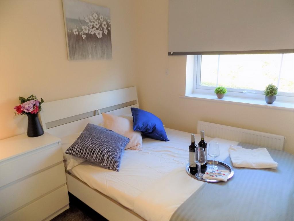Bright, neatly presented bedroom with a white b...
