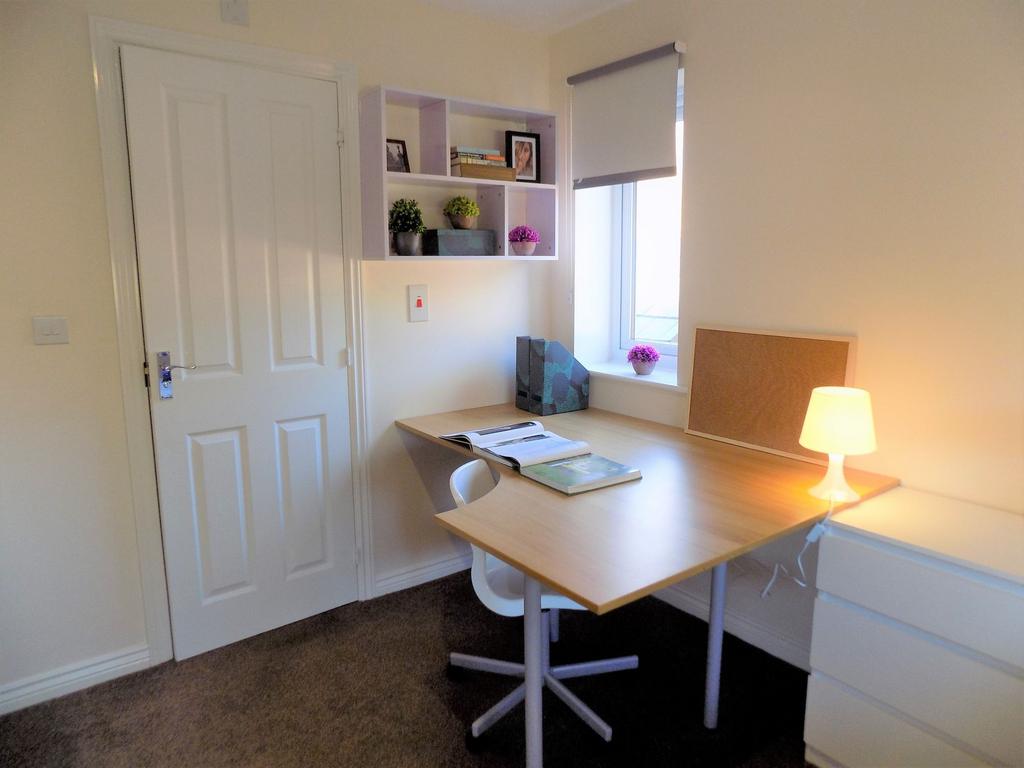 Bright, tidy study corner with a large wooden d...