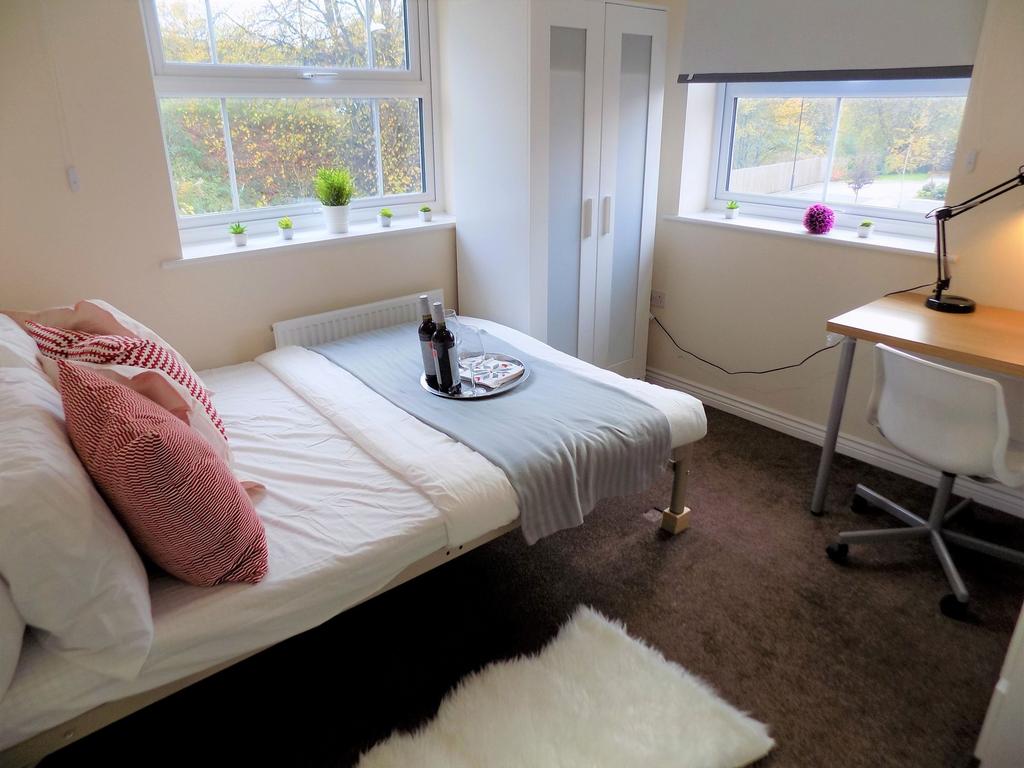 Bright, neatly furnished single bedroom with a ...