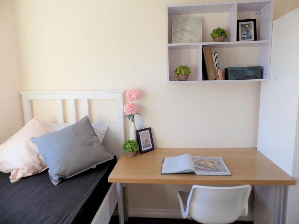 Bright, neatly styled bedroom with a simple whi...