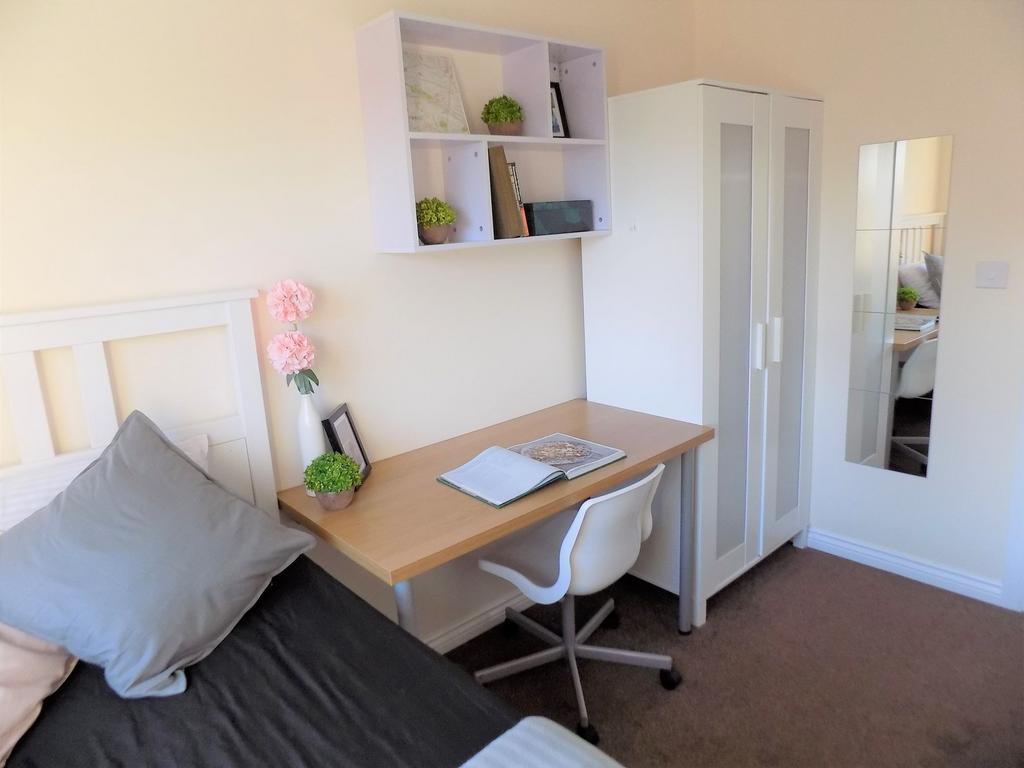 Bright, neatly furnished single bedroom with a ...