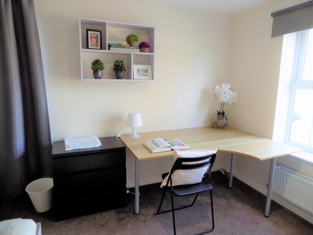Bright, neatly furnished bedroom corner with a ...