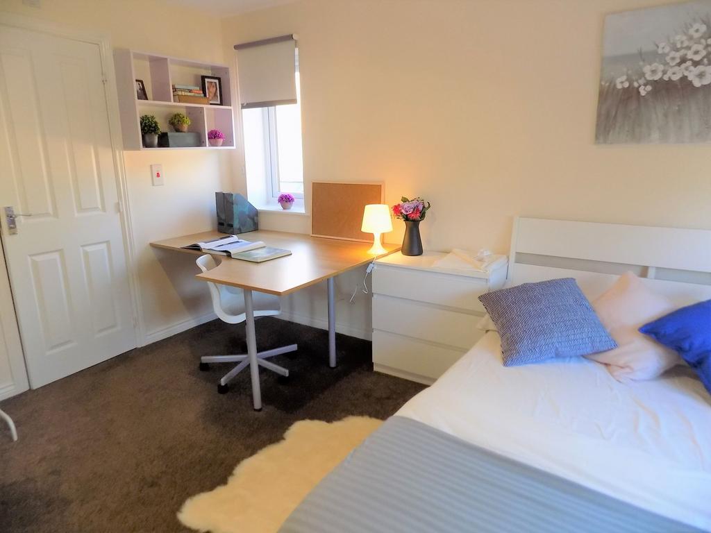 Bright, neatly presented bedroom with a built-i...