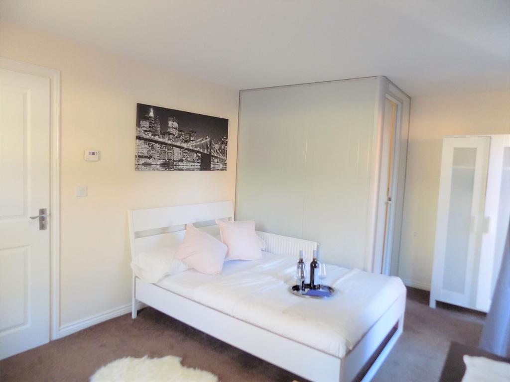 Bright, modern double bedroom with a white bedf...