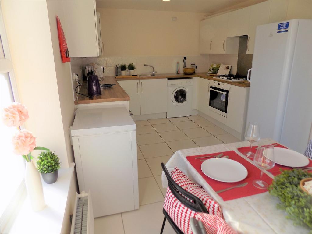 Bright modern galley kitchen with white cabinet...