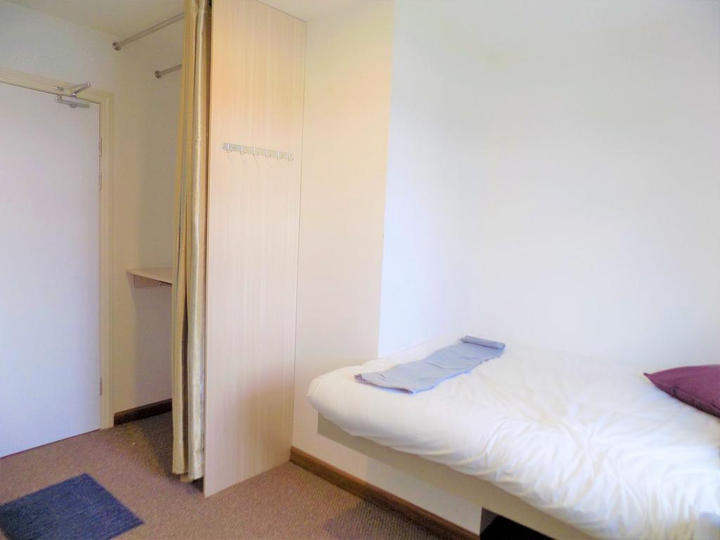 Bright, simply furnished single bedroom with a ...