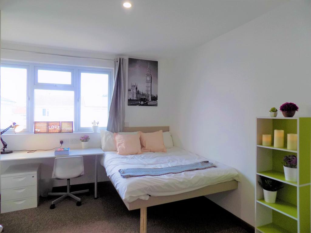 Bright, neatly furnished bedroom with a double ...