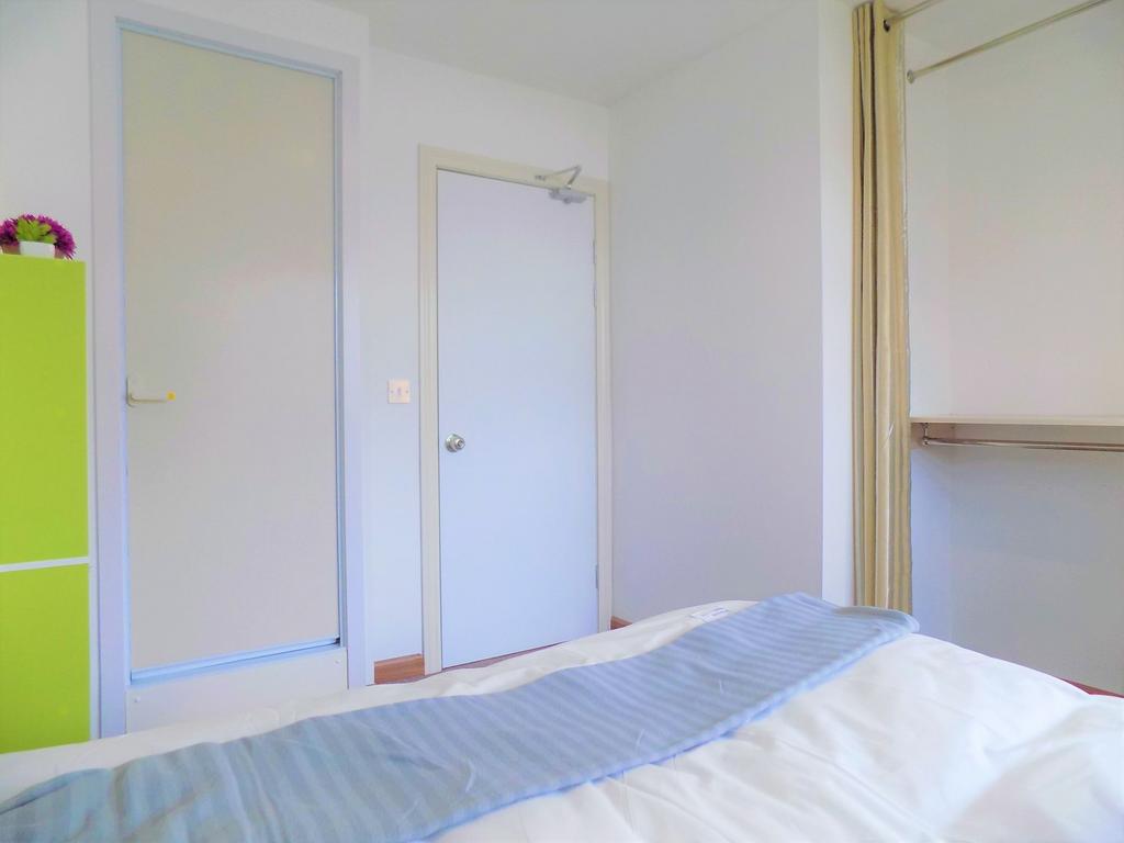 Bright, tidy bedroom with fresh white walls, a ...