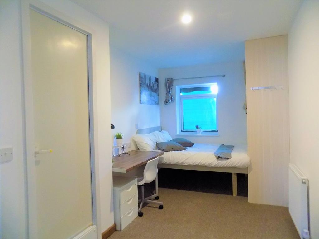 Bright, neatly arranged bedroom with a comforta...