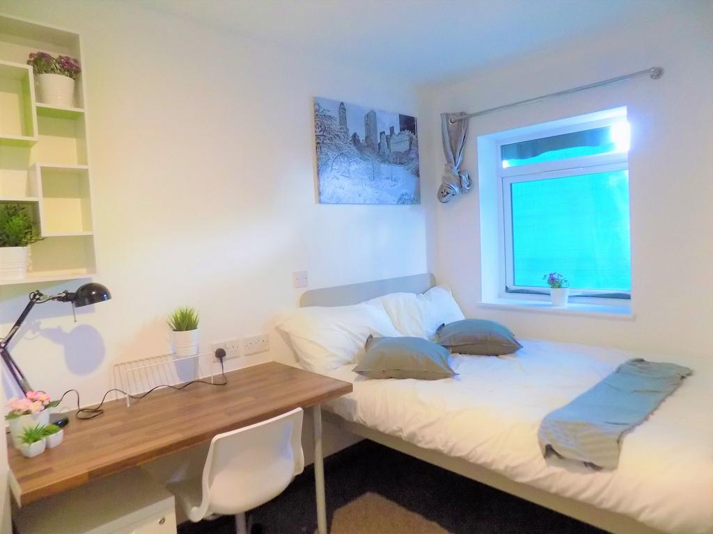 Bright, neatly furnished bedroom with a double ...