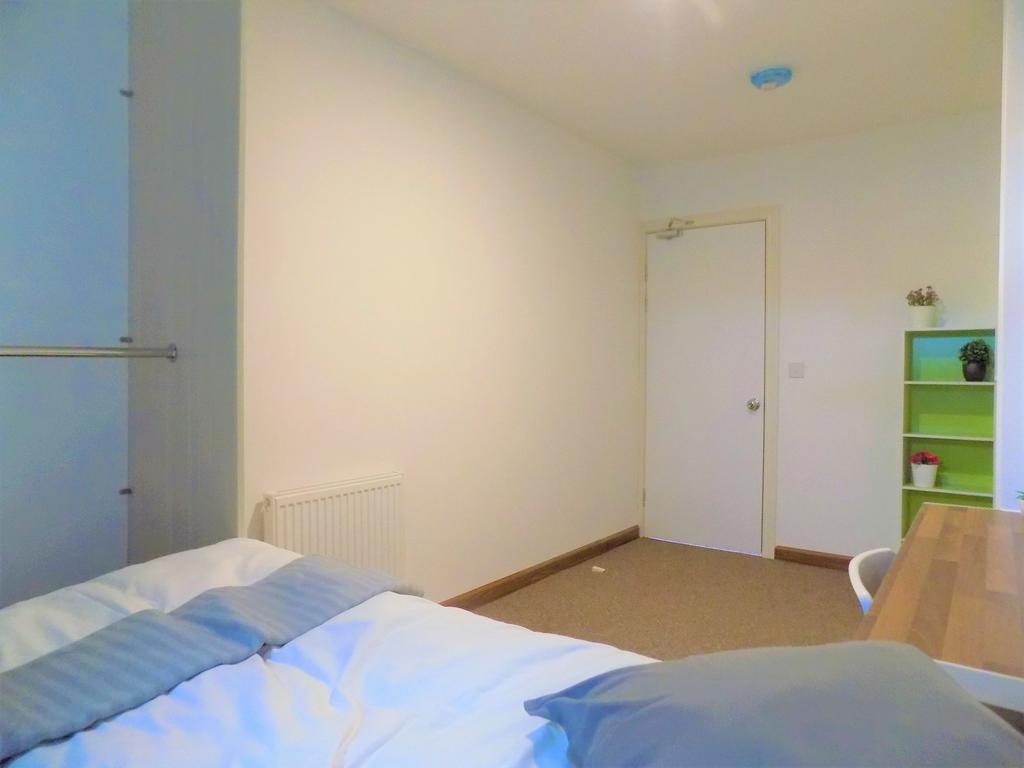 Bright, simply furnished bedroom with a comfort...