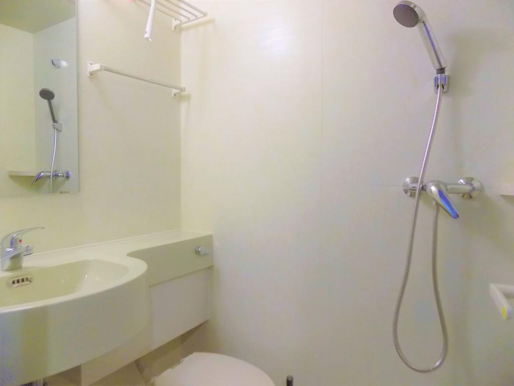 Bright, compact bathroom with a wall-mounted si...