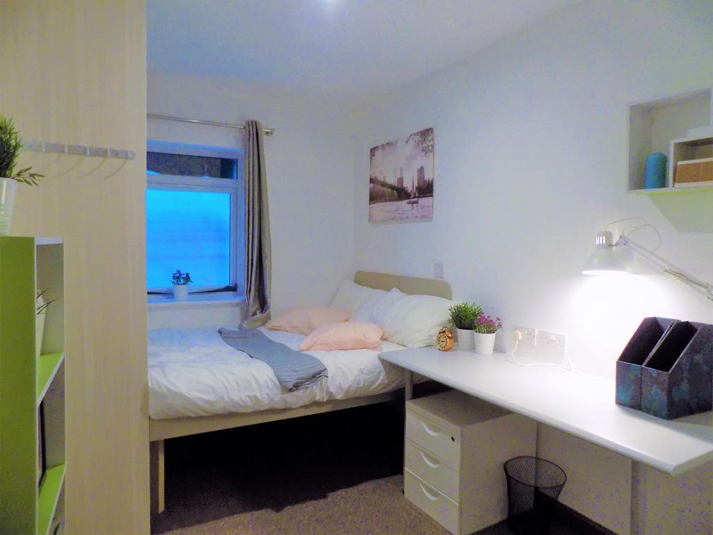 Bright, neatly styled bedroom with a comfortabl...