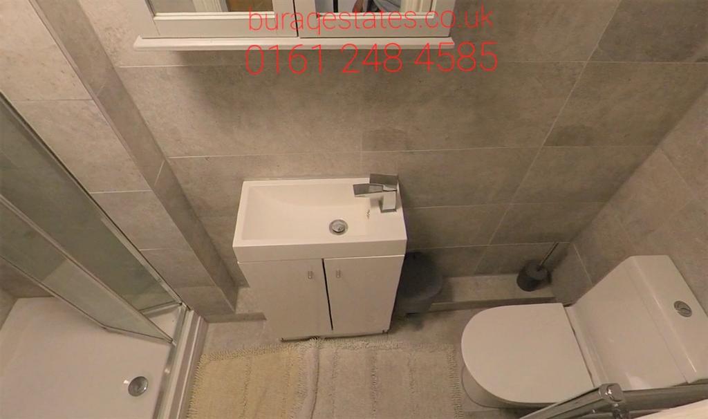 Modern tiled bathroom with a corner shower, com...