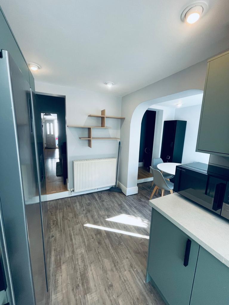 Bright modern kitchen with pale cabinetry, wood...