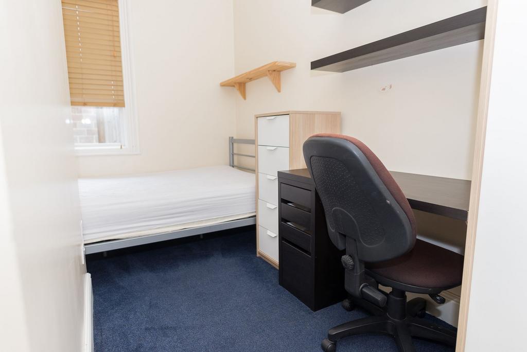 Neatly furnished single bedroom with a fitted d...