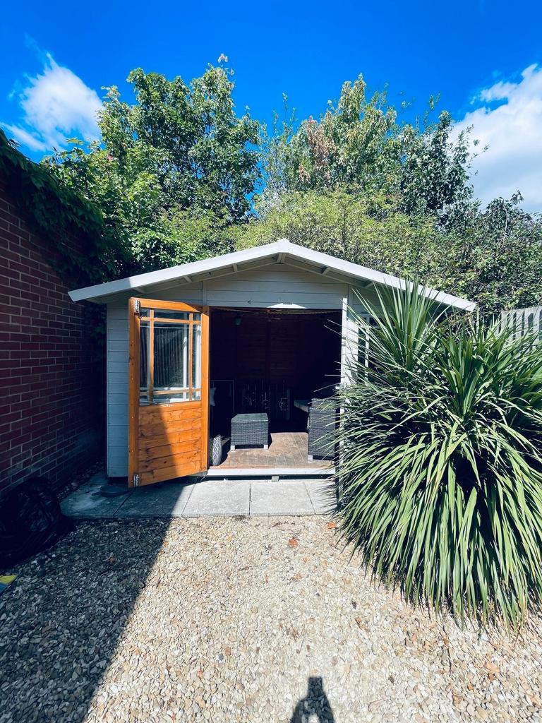 Well-kept private garden area with a quaint woo...