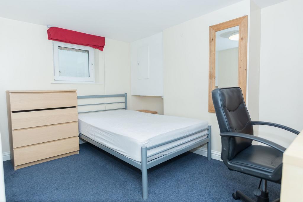 Bright, simply furnished bedroom with a metal-f...