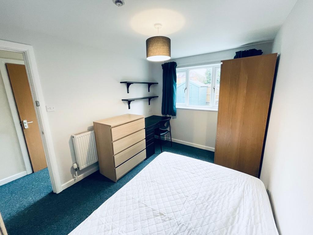 Bright, simply furnished double bedroom with a ...