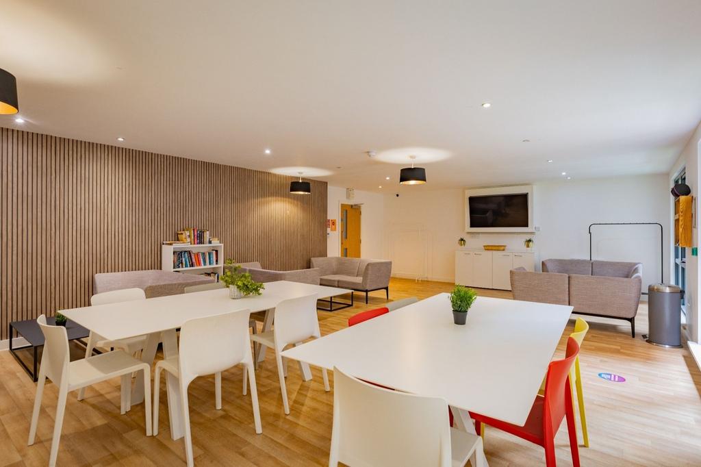 Bright, modern communal lounge with large dinin...