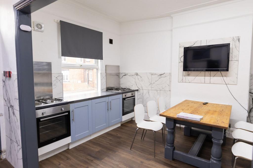 Bright and modern kitchen with blue cabinetry, ...