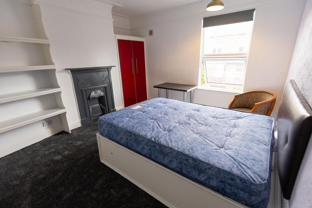 A well-lit bedroom featuring a comfortable bed ...