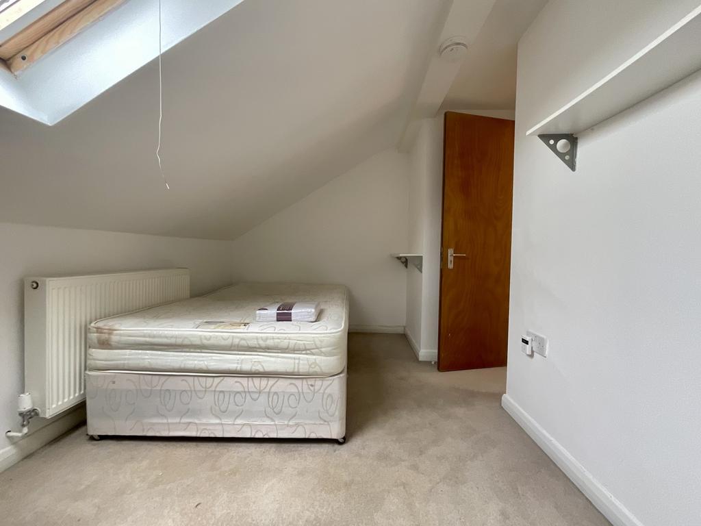 Bright attic bedroom with a large skylight, neu...
