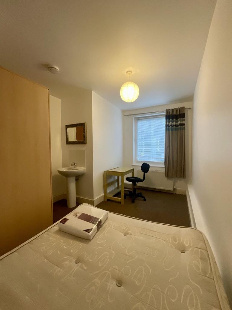 Bright, simply furnished single bedroom with a ...