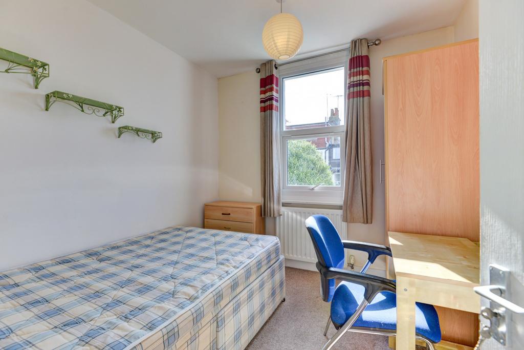 A cozy single bedroom featuring a single bed, a...