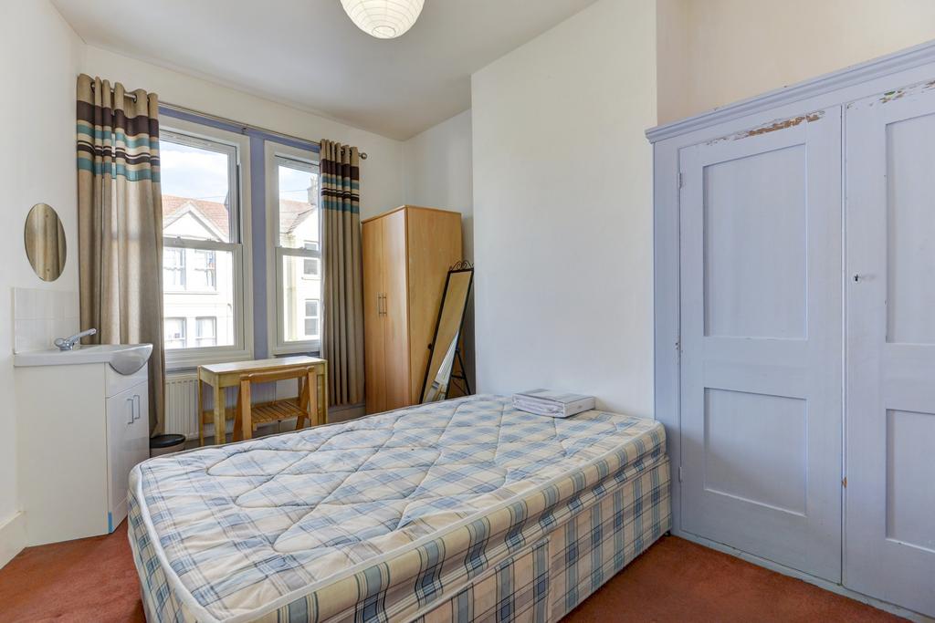 A cozy single bedroom featuring a single bed, a...