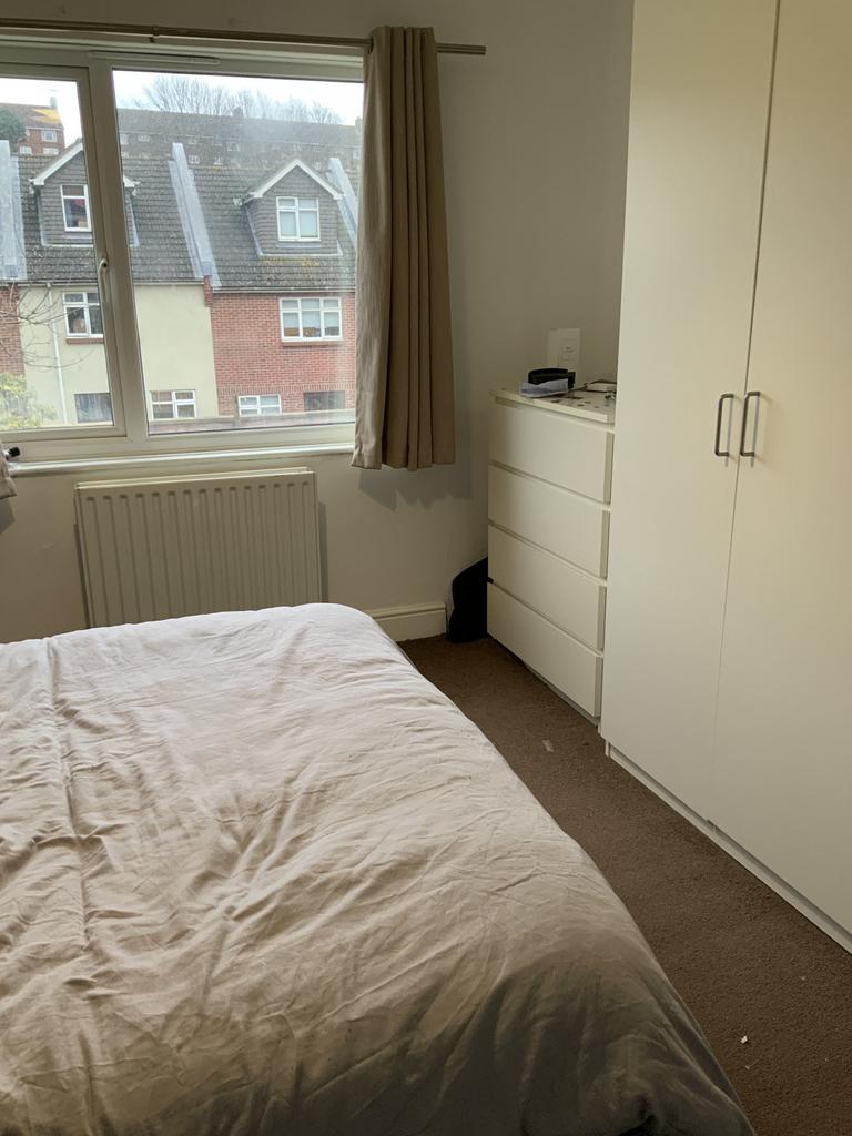 A cozy bedroom with a neatly made bed and ample...