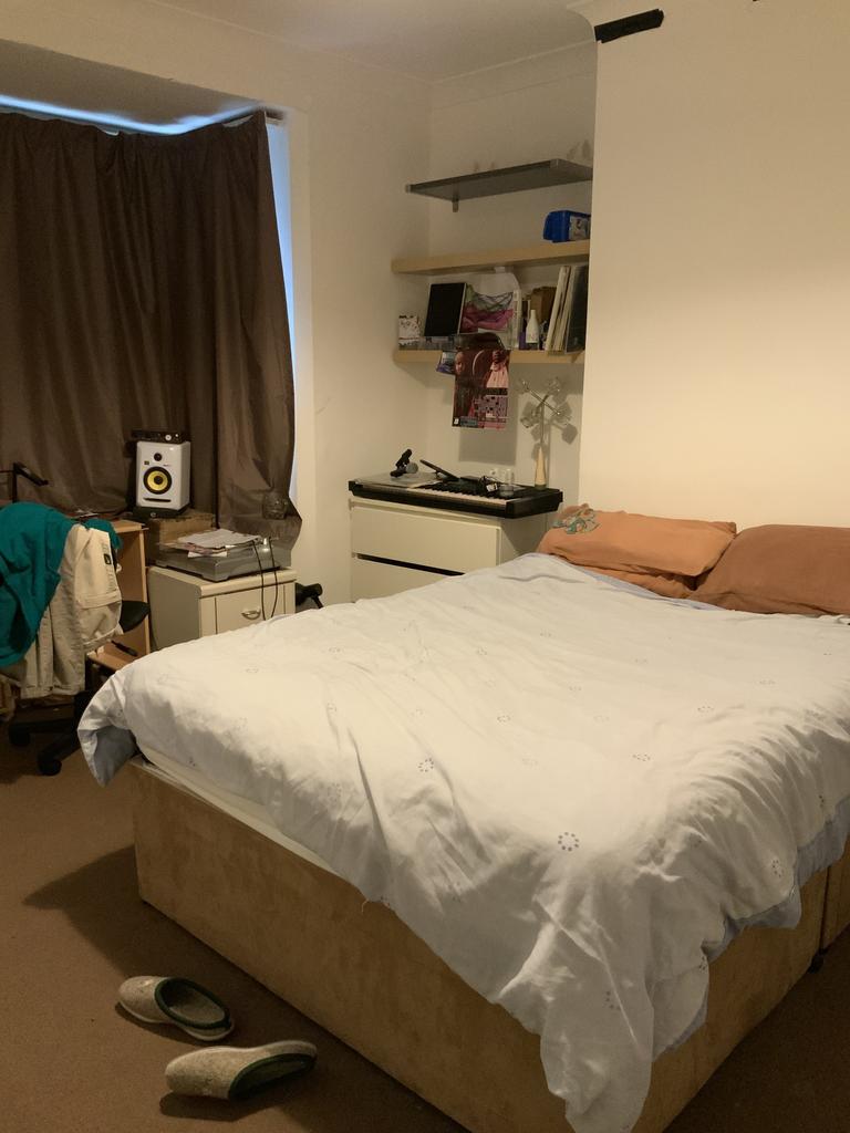 A cozy master bedroom featuring a neatly made b...